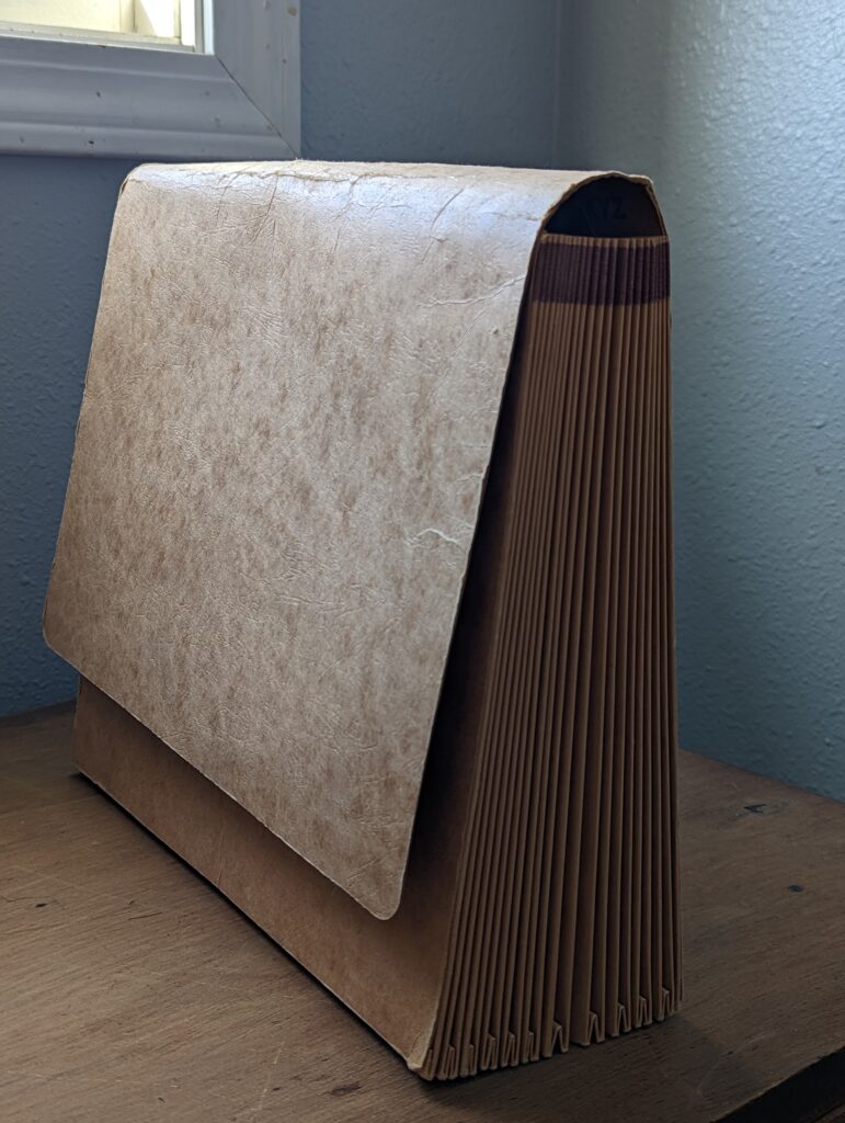 An old, brown accordion file for storing paperwork.